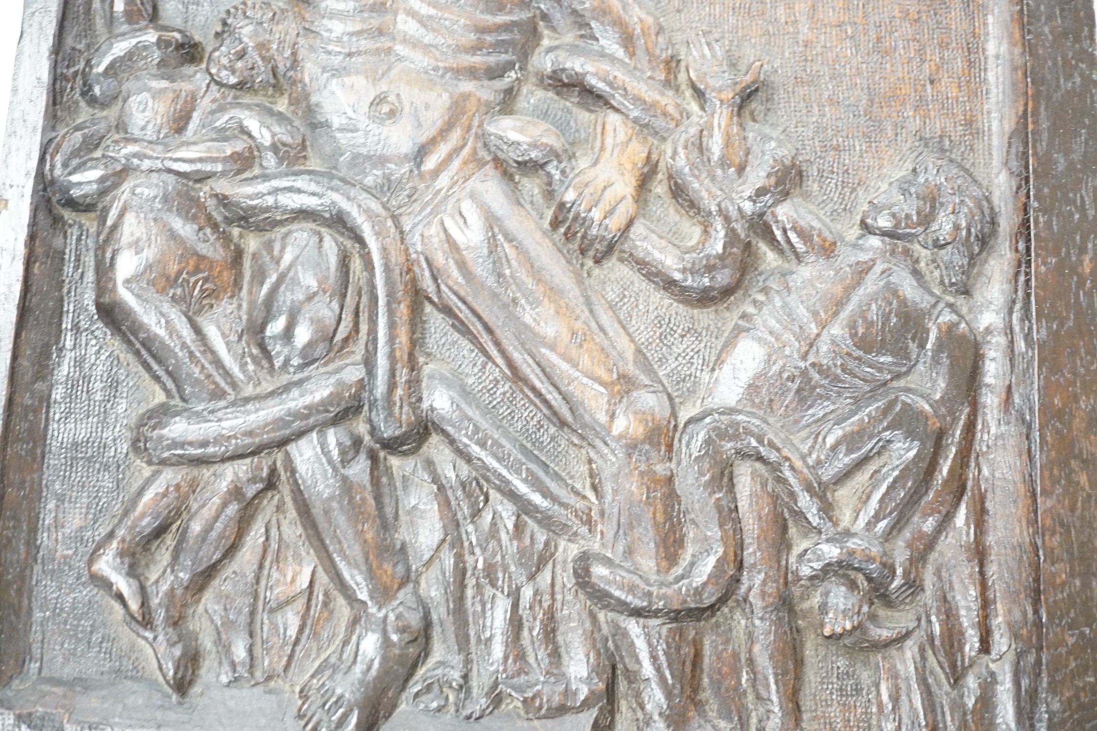 A carved oak figural panel depicting Laocoön and his son is fighting serpents, 46 x 32cm